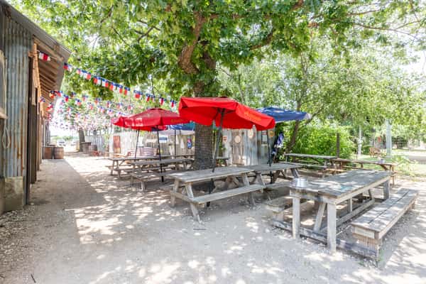Exterior benches with table umbrellas at Spechts Texas