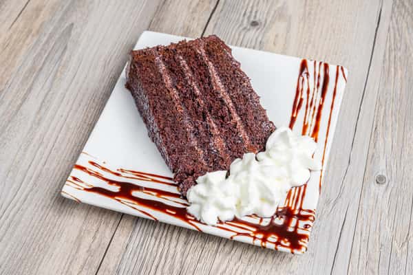 Chocolate layer cake with whipped cream and chocolate drizzle at Spechts Texas Bar & Grill.