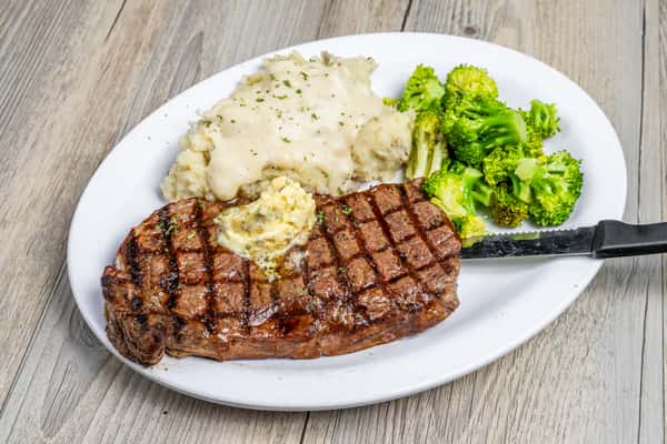 Grilled ribeye steak served with creamy mashed potatoes and broccoli at Spechts Texas Bar & Grill.