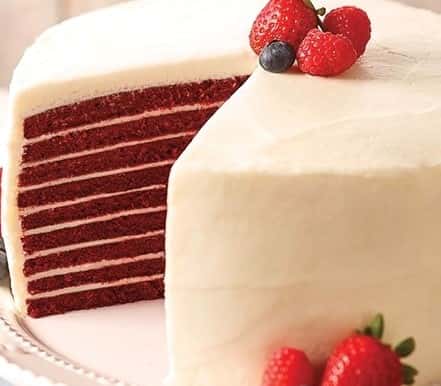 red velvet layered cake topped with fresh berries