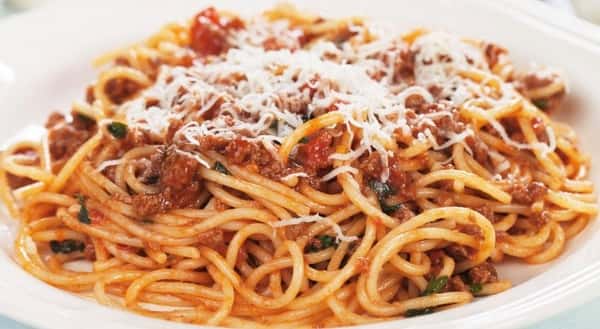 spaghetti and meatballs topped with cheese and tomato sauce