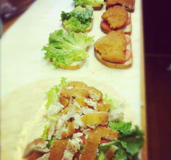 Chicken, lettuce, and tomato sandwiches being prepared