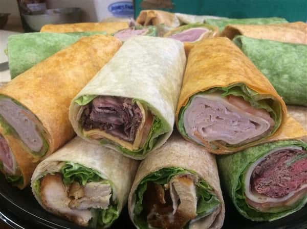 Up close photo of chicken and ham wraps stacked on top of each other