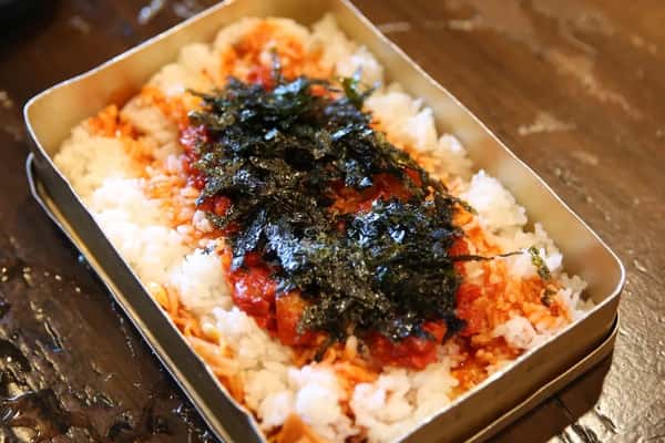 Korean dosirak lunchbox with white rice, spicy kimchi, and shredded seaweed served in a metal container.
