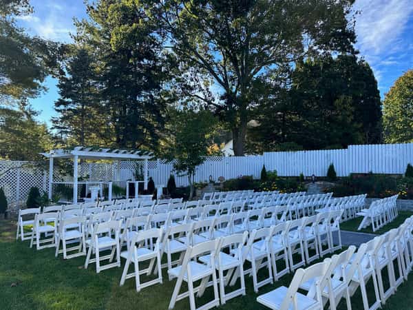 white ceremony chairs on lawn