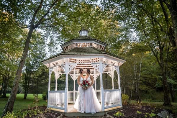 two brides standing in gazebo