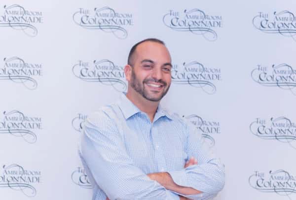 Man smiling in front of backdrop