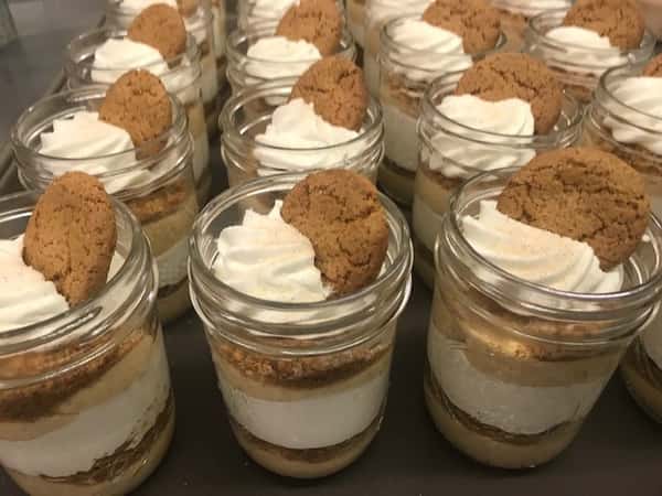 mason jar filled with dessert and a cookie on top