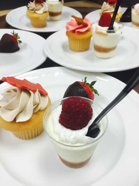 cupcake, chocolate covered strawberry, and mousse dessert on white plate
