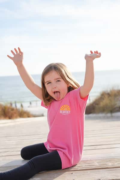 kid waving her hands up with tongue out