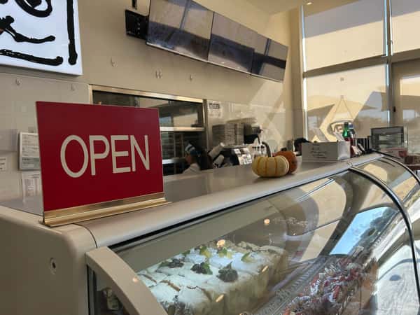 display case of desserts with red 'Open' sign on counter
