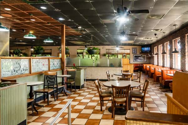 The dining area of The Butcher Shop restaurant with tables, chairs, and a checkered floor
