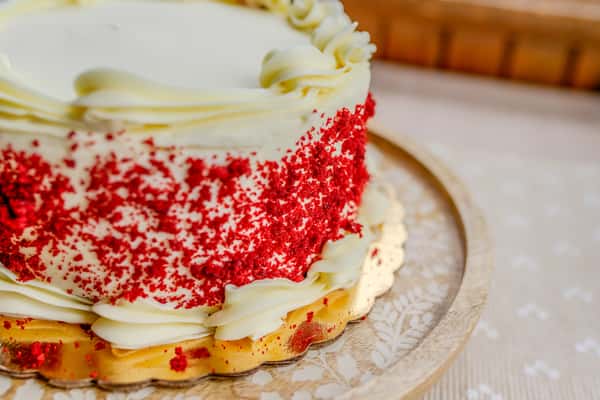 A slice of red velvet cake with cream cheese frosting and red velvet crumbles from The Butcher Shop bakery