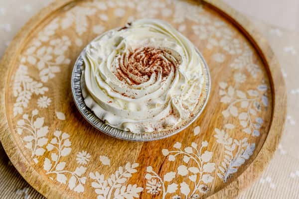A chocolate cream mini pie topped with whipped cream and chocolate drizzle from The Butcher Shop bakery