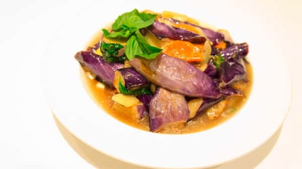 bowl of soup with red cabbage, vegetables, and basil