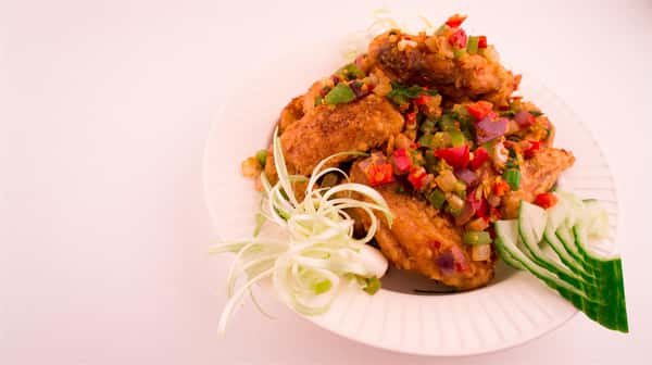 fried chicken topped with chopped assorted vegetables