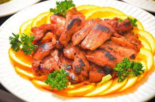 plate of pork short ribs on top of sliced oranges