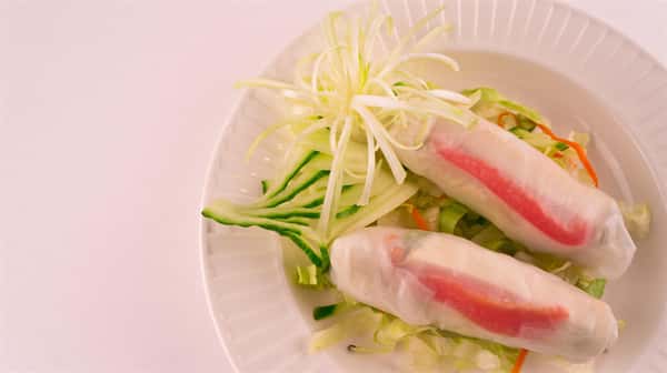 rice paper spring roles with crab and vegetables, on a bed of greens