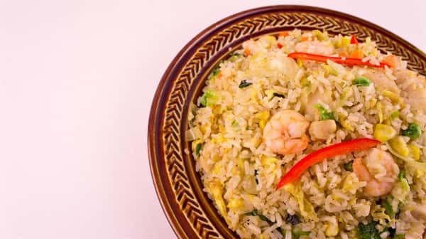 plate of fried rice, shrimp, corn, scallions, peppers, eggs, and peas