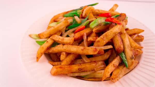 asian-style poutine, with onion, peppers, scallions, and french fries in a sauce