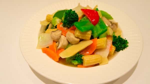 bowl of steamed vegetables, including baby corn, broccoli, peppers, carrots, and mushrooms