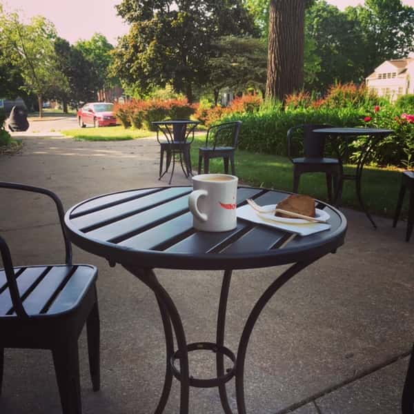 outdoor seating; coffee and a pastry on a cafe table at the grind location