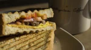 grilled sandwich with coffee mug in background