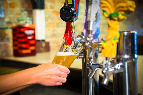 Person pouring beer from tap