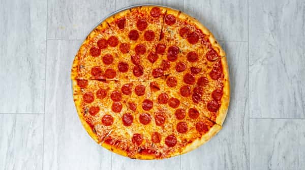 Pepperoni pizza, sliced into eight wedges, with melted cheese on a round metal tray.
