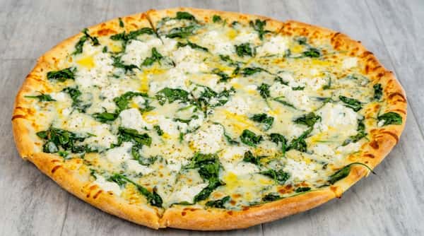 White pizza with ricotta cheese, mozzarella, spinach, and oregano on a wooden surface.