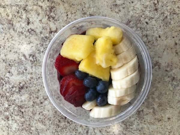 acai bowl with pineapples, bananas, blueberries, and strawberries