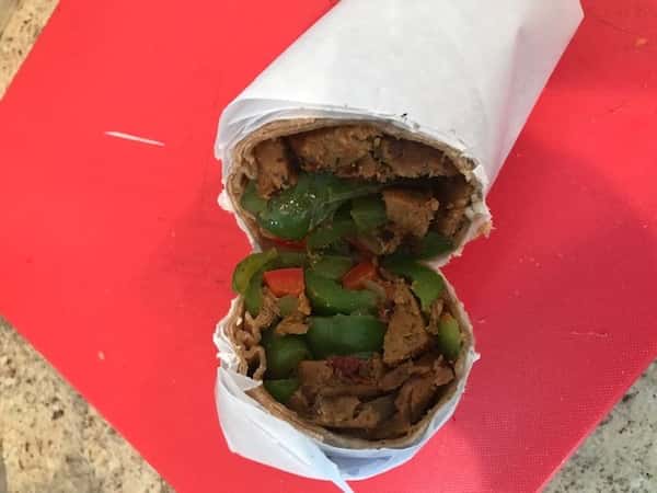 Wrap covered in paper stuffed with vegetables and meat