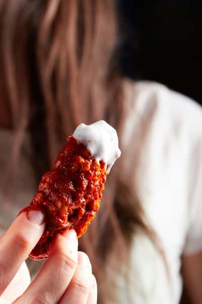 Woman holding a chicken wing