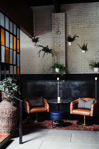 Secluded dining space with leather lounge chairs and greenery decor