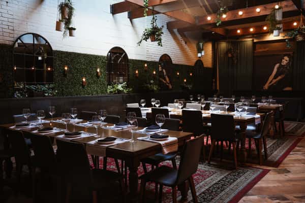 Outdoor patio semi-private dining with natural greenery wall and lush outdoor carpets