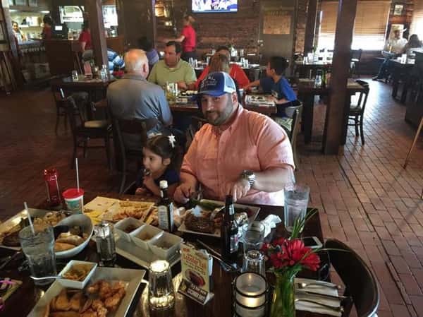 male sitting at table cutting steak