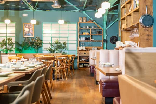 Interior of restaurant with tables laid and large windows