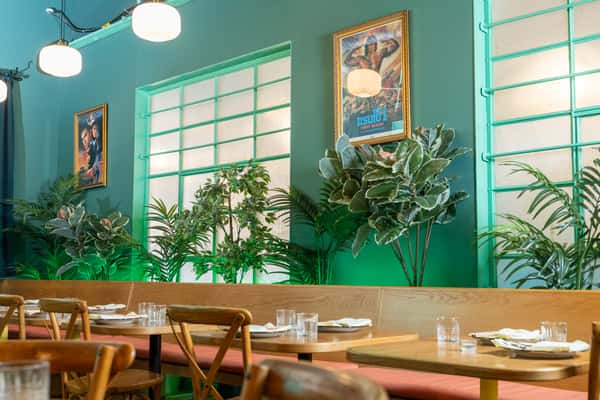 Interior of restaurant with tables laid and large windows