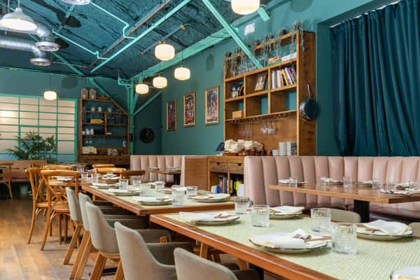 Interior of restaurant with tables laid and large windows