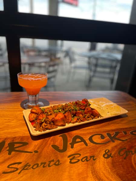Appetizing image shows a dip served with toasted pita bread along with a drink on a bar. Text reads "Mr. Jack's Sports Bar & Grill".