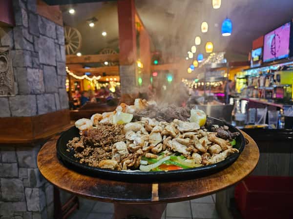 Double Fajita Grande; steak, chicken, chorizo, and shrimp served on a bed of fajita veggies on a sizzling platter