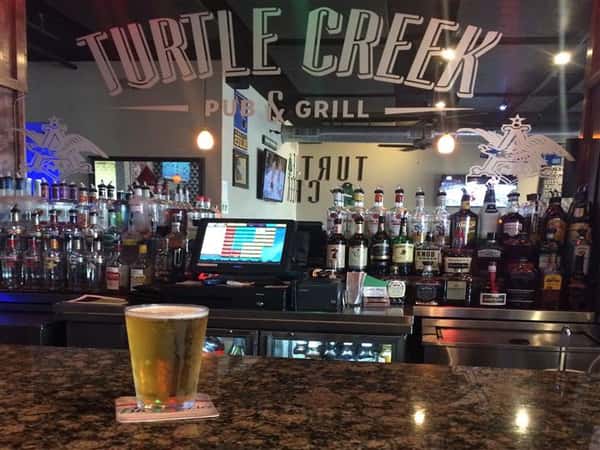 turtle creek pub & grill bar with a pint of beer on the counter