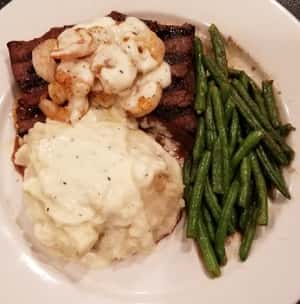 1/2 pound Pub Sirloin topped with grilled shrimp. Mashed potatoes and green beans on the side.