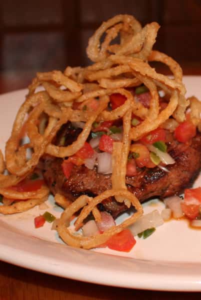 grilled steak with fried onions and tomatoes