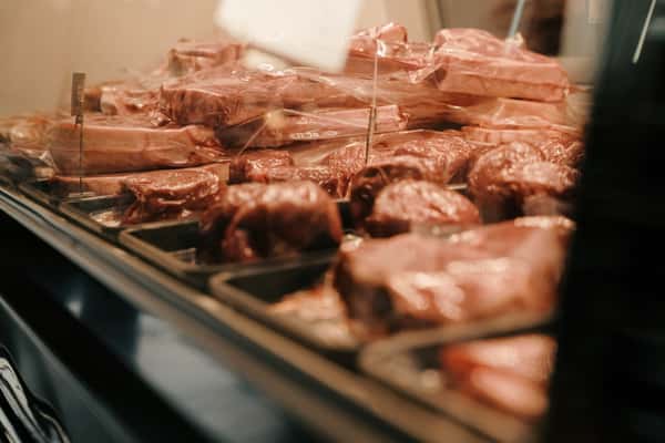 Assortment of vacuum-sealed steaks and prime cuts displayed in a butcher-style meat case, ready for grilling or dry-aging.