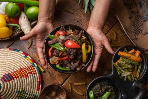 Hands holding a bowl of fajita mexican food