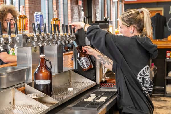 Bottles being filled by a staff member with beer