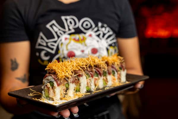 Signature surf and turf sushi roll topped with crispy garnish at Kapow! Noodle Bar, featuring premium seafood, bold flavors, and elevated Asian fusion craftsmanship.