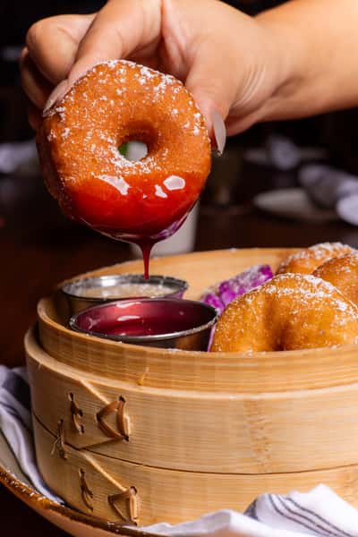 Glazed dessert donuts served with dipping sauce at Kapow! Noodle Bar, featuring a creative sweet treat perfect for sharing after an Asian fusion meal.
