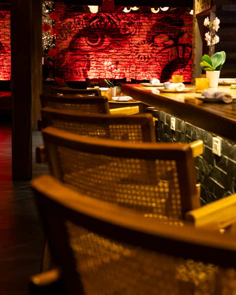 Stylish bar seating at Kapow! Noodle Bar showcasing warm wood finishes, contemporary design, and a sophisticated atmosphere for craft cocktails and Asian fusion dining.